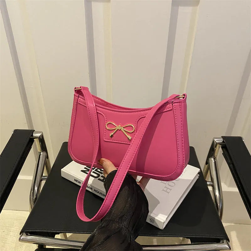 Western style PU leather shoulder bag in horizontal square shape with bow decoration, shown in rose pink colour.