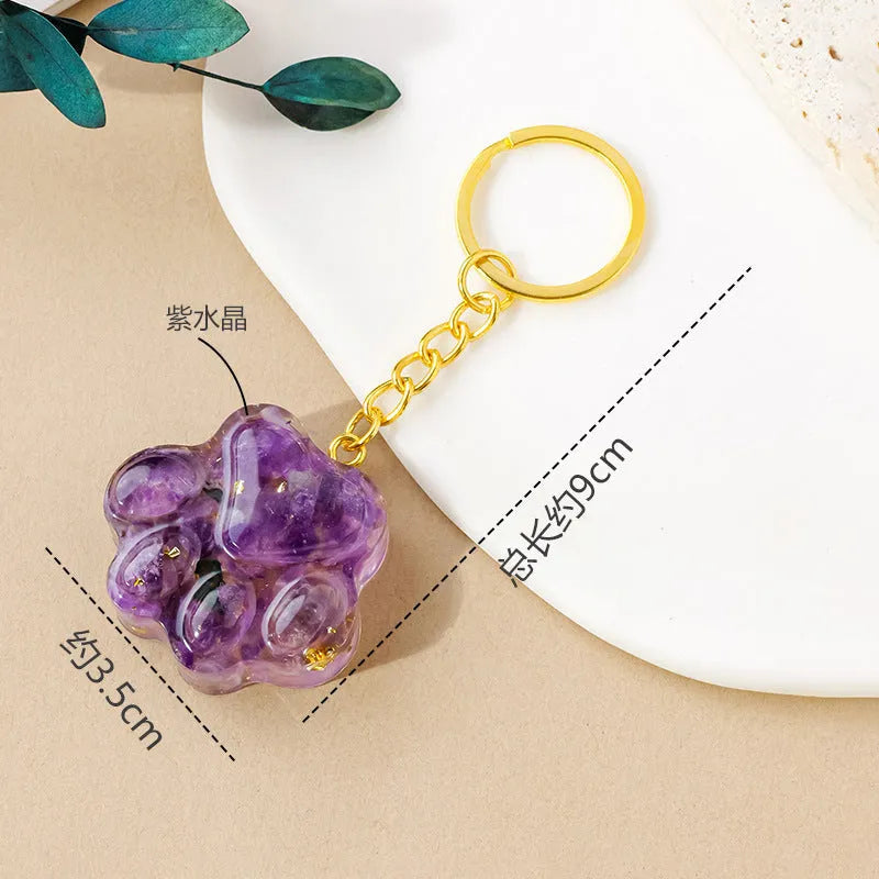 Hand-carved natural crystal cat's paw keychain pendant on a metal ring, showing unique gemstone colour.