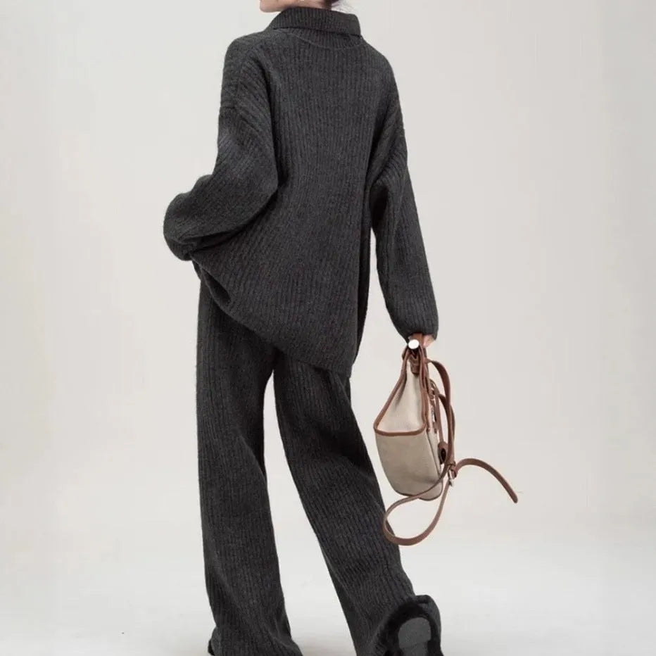 Beige women's knitted sweater suit set with collage stitch detail on top and trousers on a hanger.