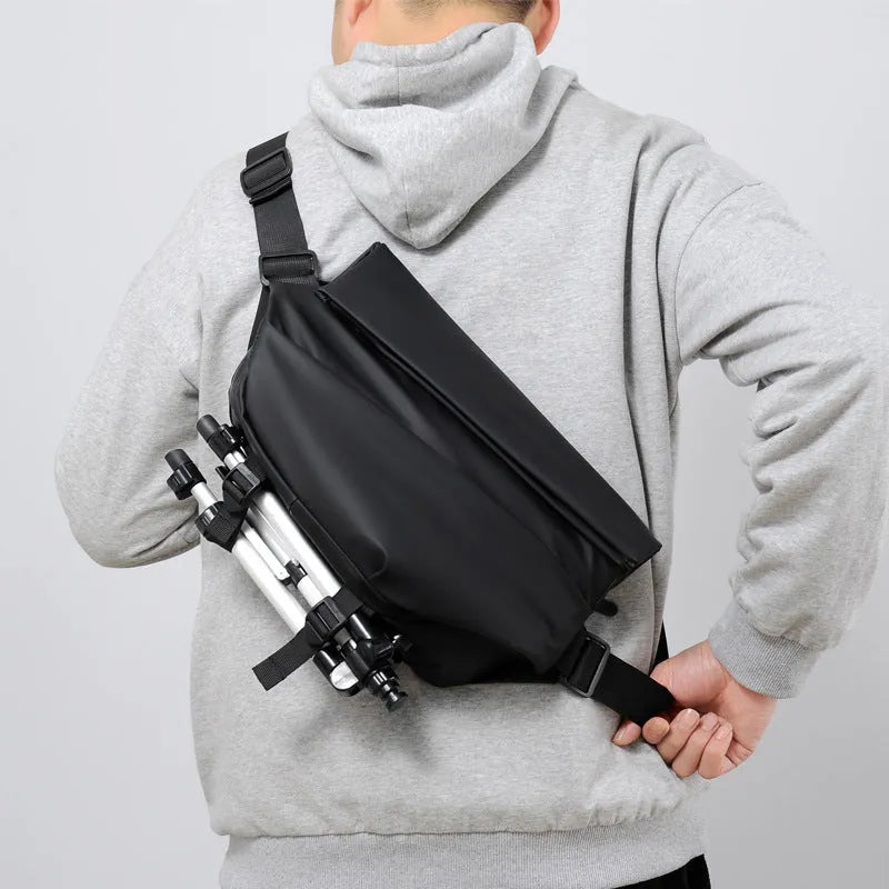 Grey crossbody bag for men showing horizontal square shape, shoulder strap, and zipper opening
