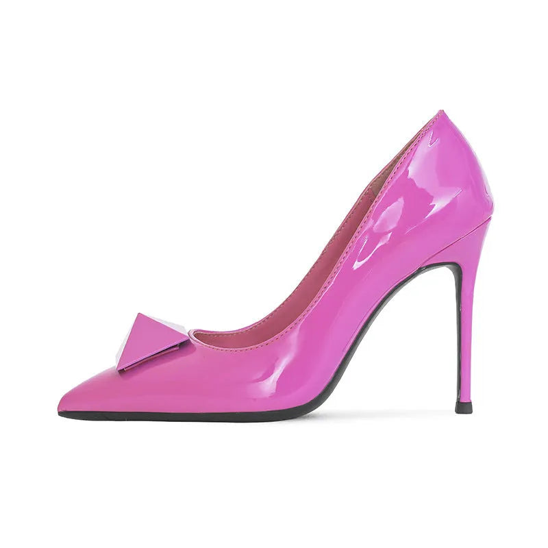Pink patent leather women's stiletto heels with pointed toe, rivet buckle, and low-cut vamp on a white background.
