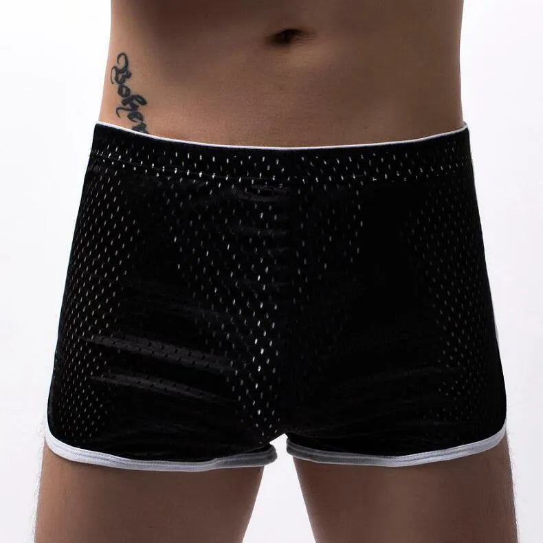 Men's grey three-point boxer shorts with a mid-rise waistband laid flat on a table.