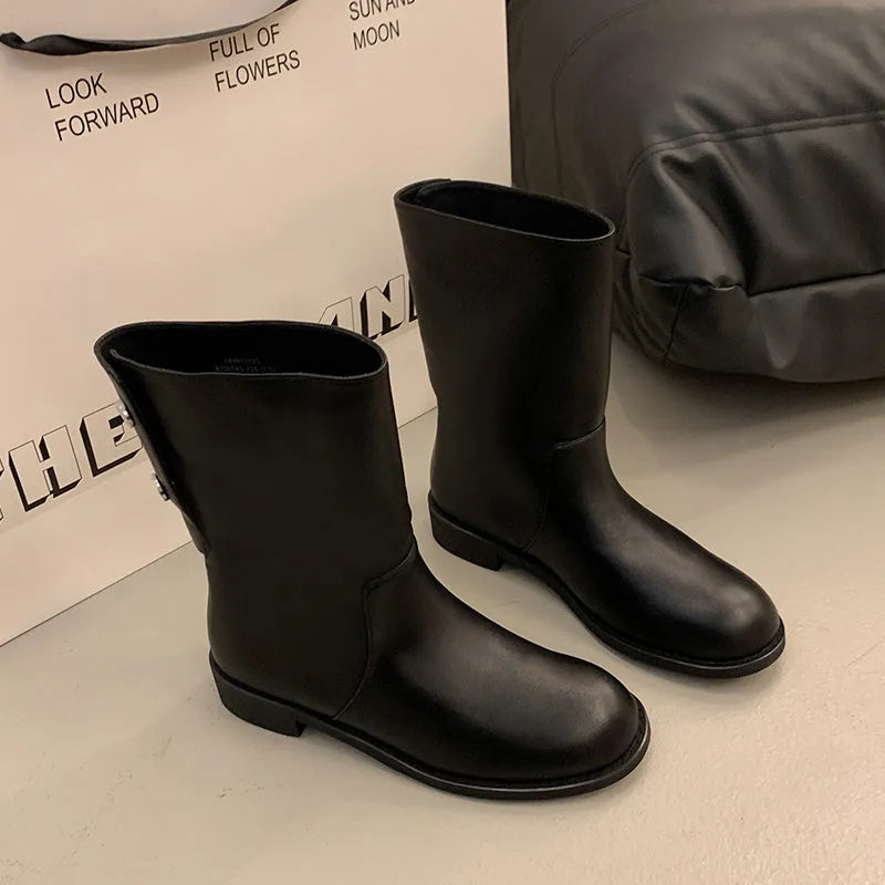 Women's black leather mid-calf platform boots with silver stud details on a white background