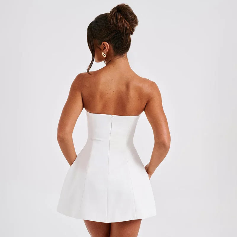 A backless solid colour tube dress on a model, showing its high waist and short A-line skirt.