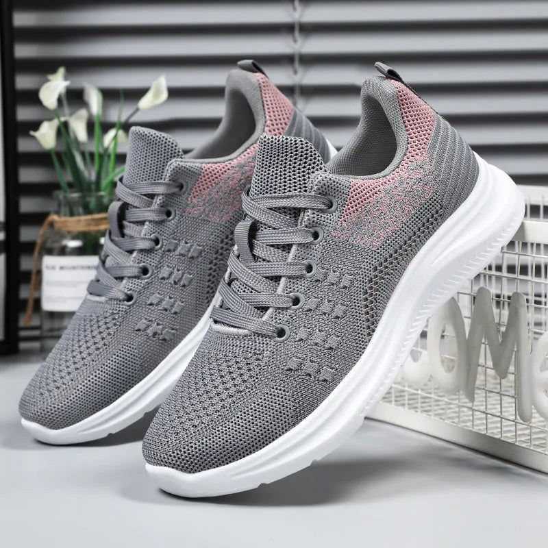 Women's low-top black mesh sneakers with lace-up front and round toe on a soft PVC sole.