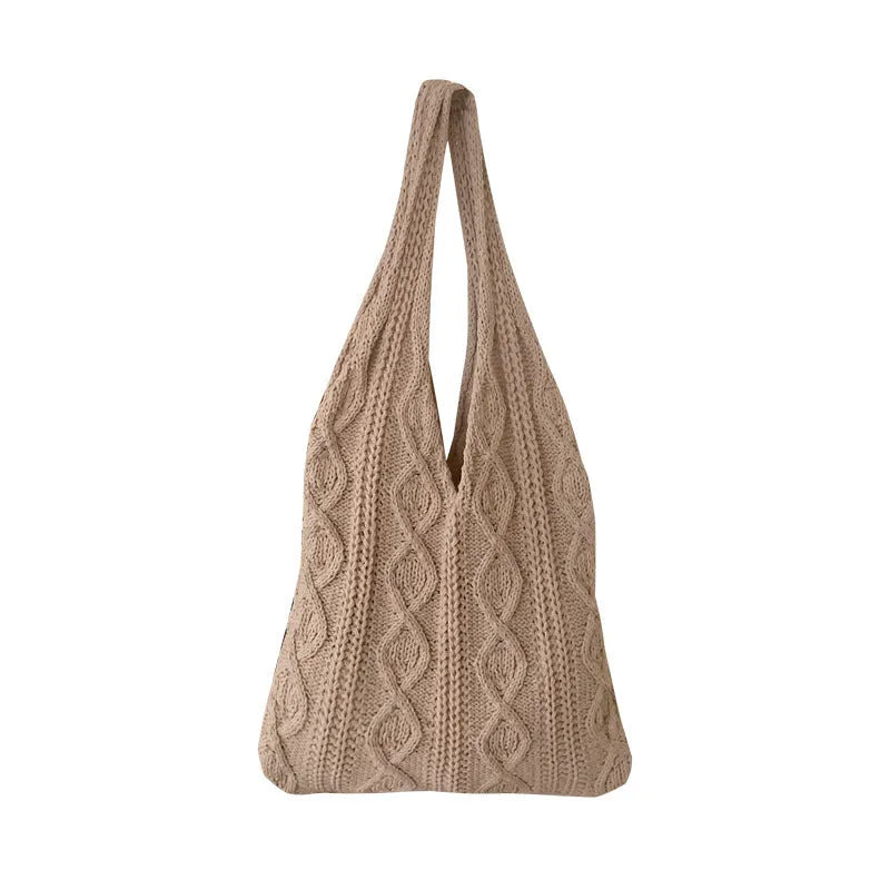 GWomens beige knitted tote bag with double shoulder straps on a wooden table.