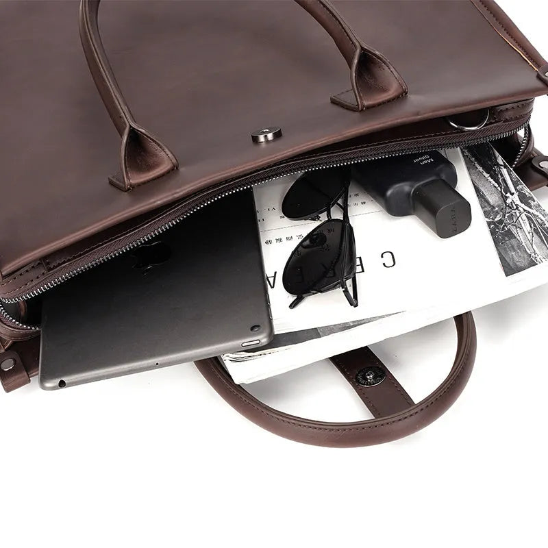 Brown men's messenger bag with soft PU surface and multiple compartments on a flat surface