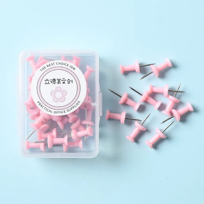 Plastic push pins in cherry blossom pink, mint green, and lavender, showing large and small sizes on a corkboard