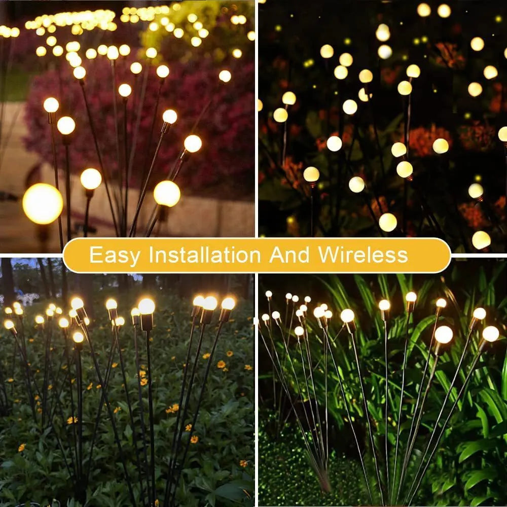 Solar-powered LED firefly garden stake light with stainless steel ground plug illuminated at dusk.
