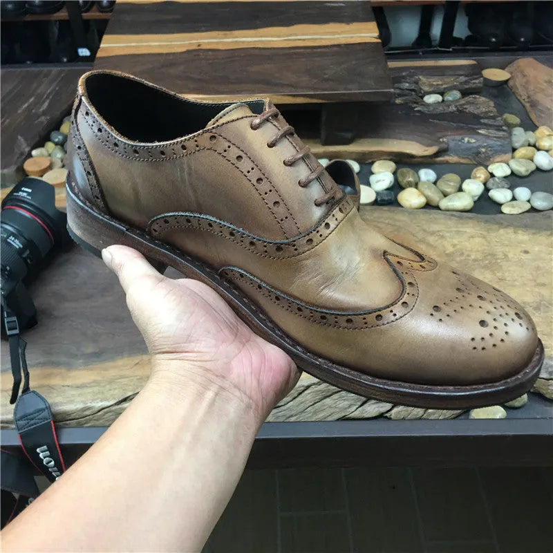 Men's light brown leather lace-up shoes with hand-distressed carving detail on the upper and a round toe.