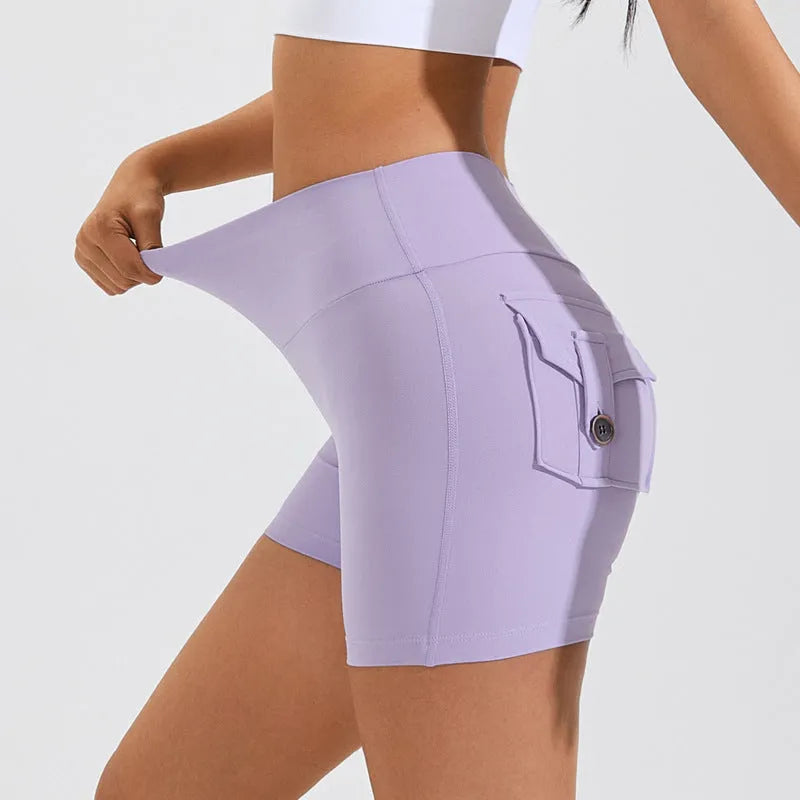 Women's high waist nylon fitness shorts in avocado green with side pockets, laid flat.