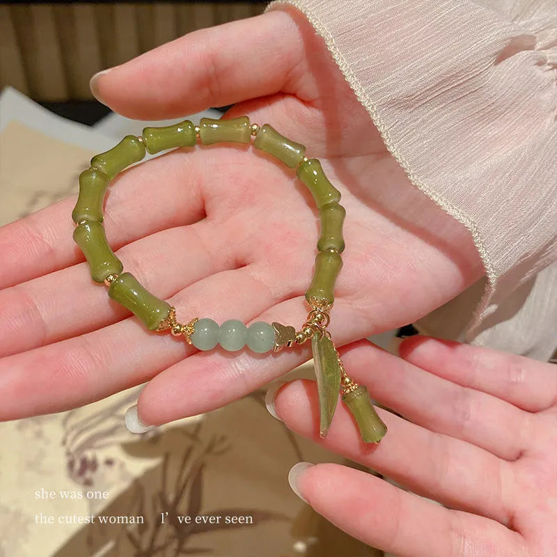 Chinese style glass bracelet with bamboo leaf design on wrist.