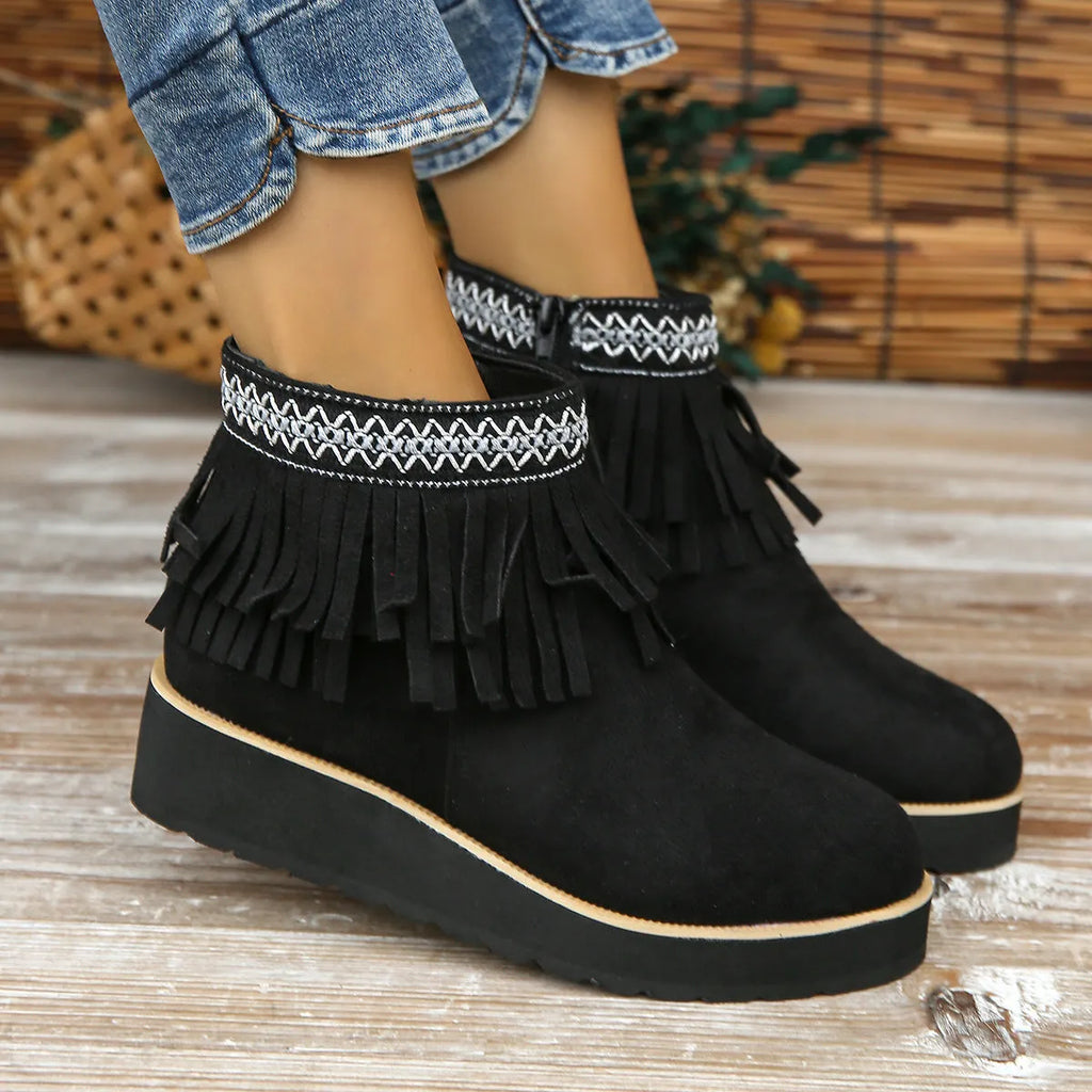Women's suede ankle boots with wedge heel, side zipper, and tassel detail in dark brown.