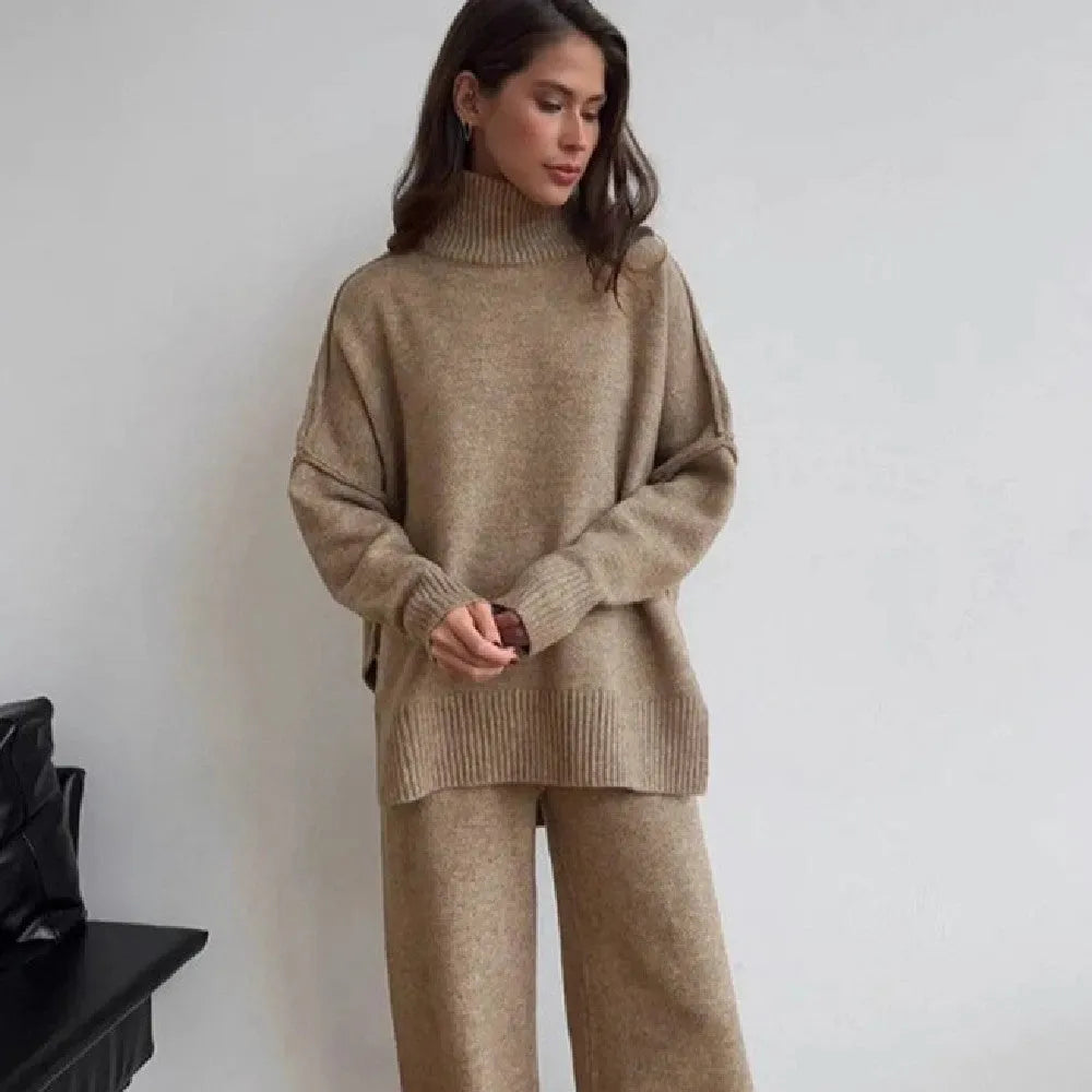 Women's dark grey acrylic knit set with side-slit top and full-length trousers laid flat.