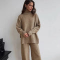 Women's dark grey acrylic knit set with side-slit top and full-length trousers laid flat.