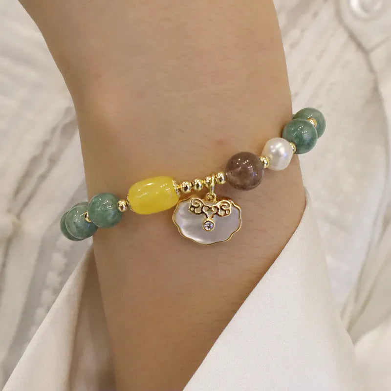 Women's green jade shell bead bracelet showing natural gemstone colour tones