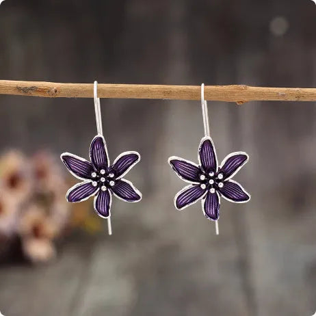 Close-up of a pair of purple alloy flower-shaped earrings with a retro elegant style.