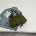 Large solid colour polyester canvas shoulder bag for women showing external pocket and strap.