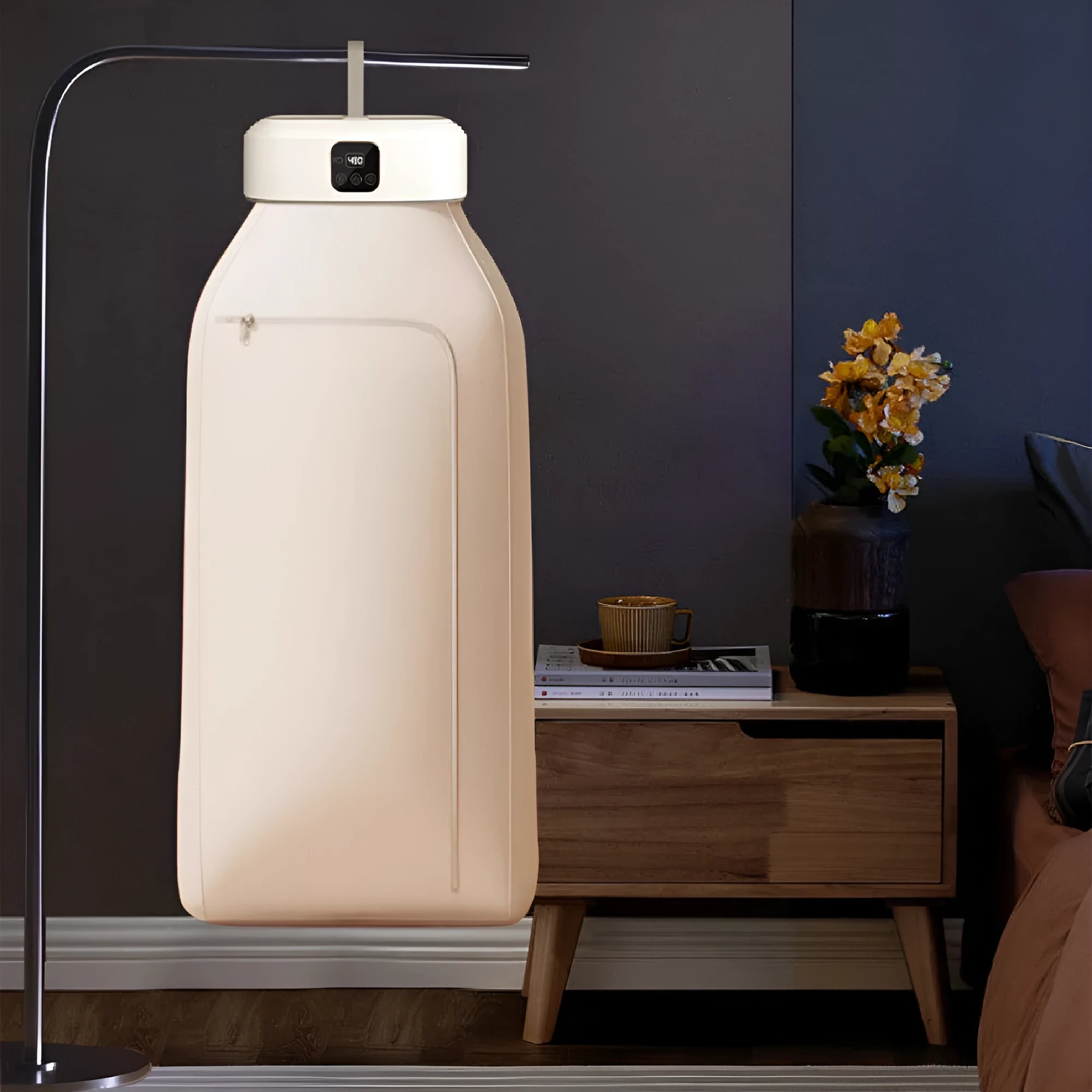 White cylindrical portable clothes dryer with remote control, folded for compact storage