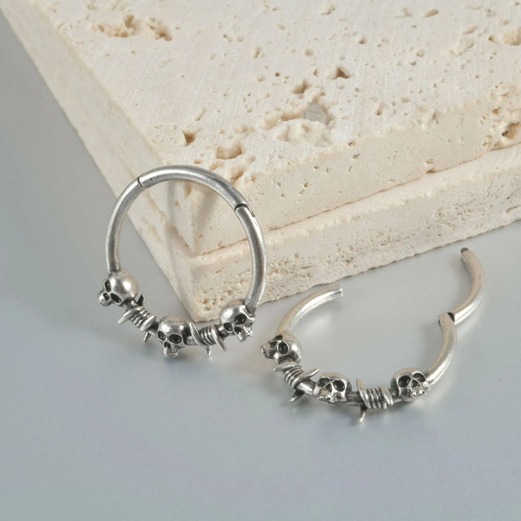 Close-up of vintage-style copper stud earrings featuring a detailed stamped ghost head motif with an antique silver finish.