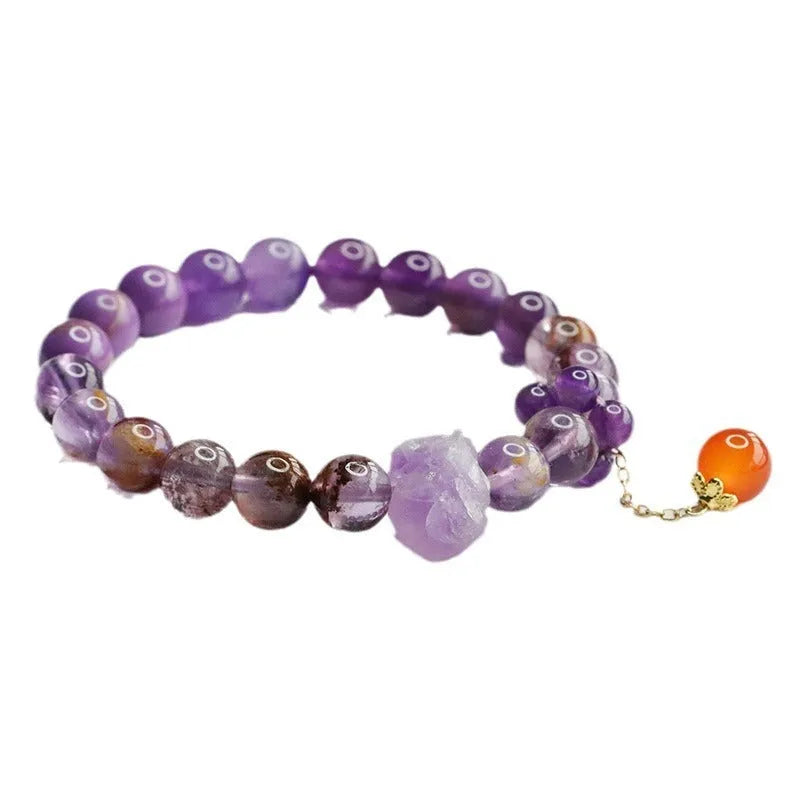 Nine purple fire amethyst and red agate Mori-style crystal bracelet on a wrist.