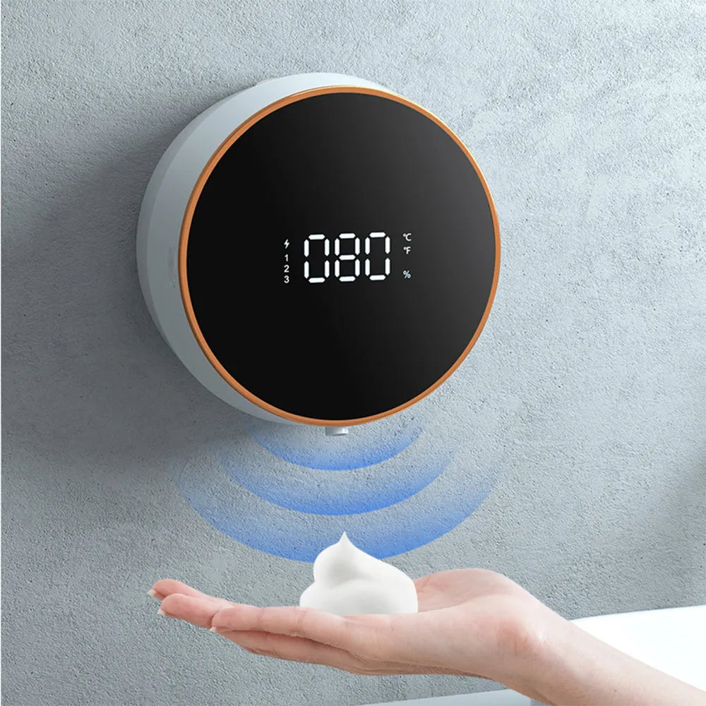 Black automatic sensor foam soap dispenser mounted on a wall with a USB cable connected.