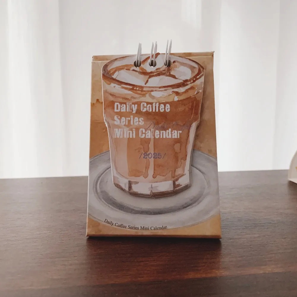 Mini coffee desk calendar 2025 with four design options on small desk surface