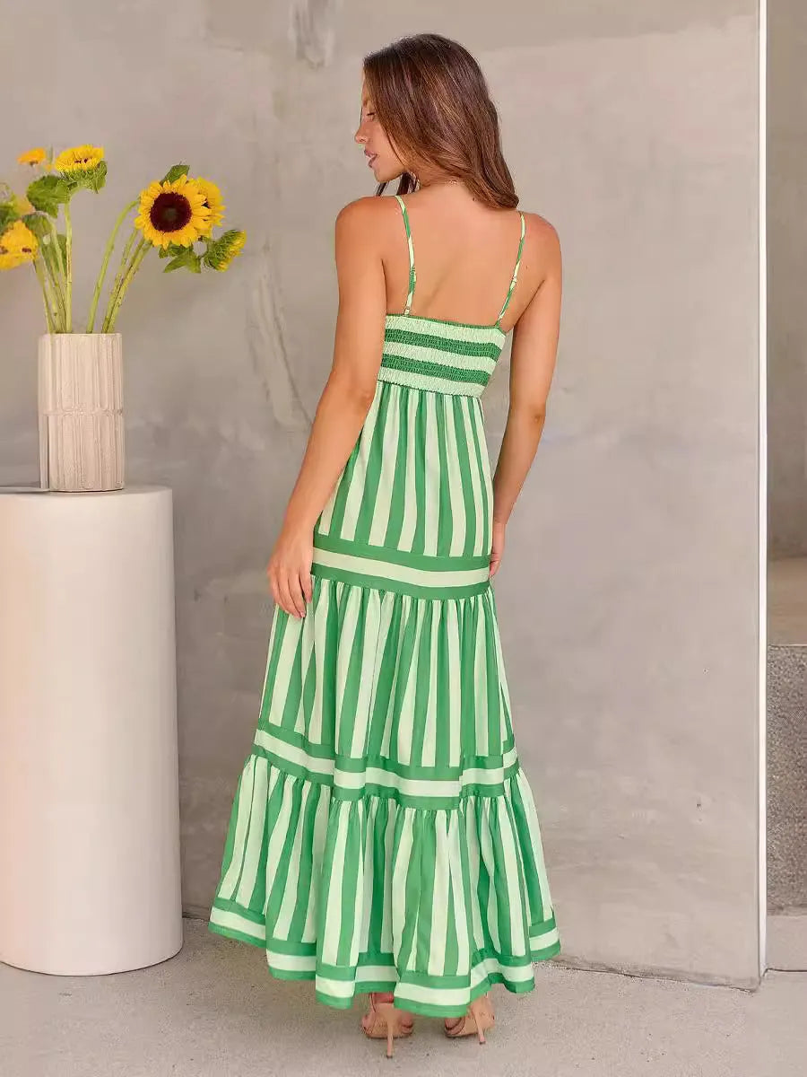 Woman wearing a striped, backless long summer dress with square neckline, suspender straps, and side pockets.