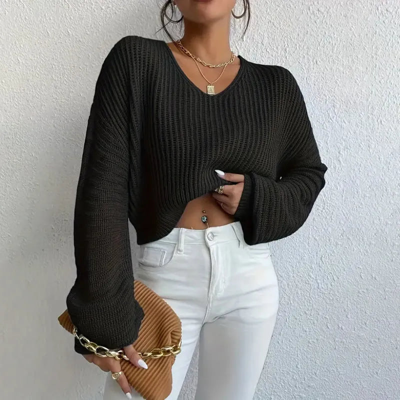 Women's solid colour long sleeve loose pullover in polyester fabric on a hanger.