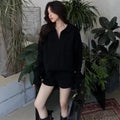 Creamy-white women's cable knit sweater and shorts set with elastic waistband on a hanger.