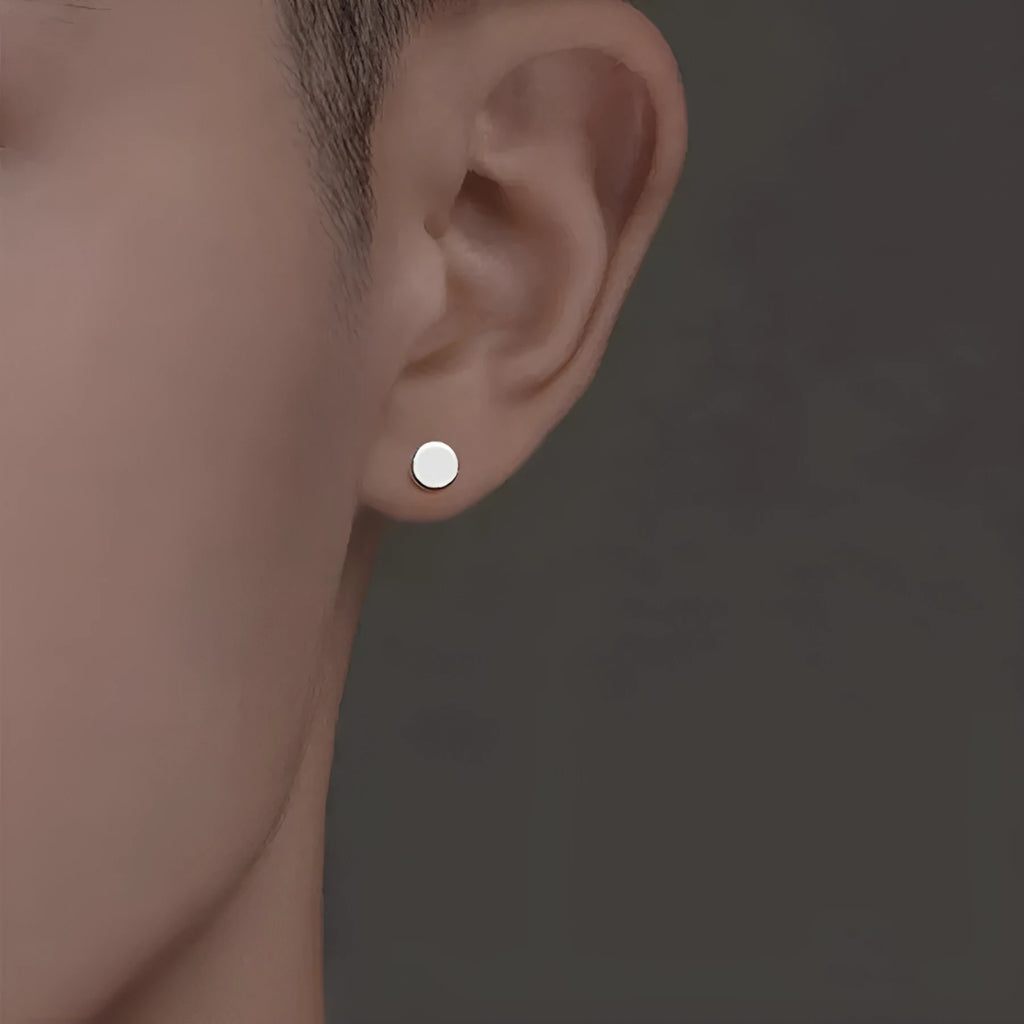 A pair of round, flat bone stud earrings in sterling silver, showing silver and black colour options.