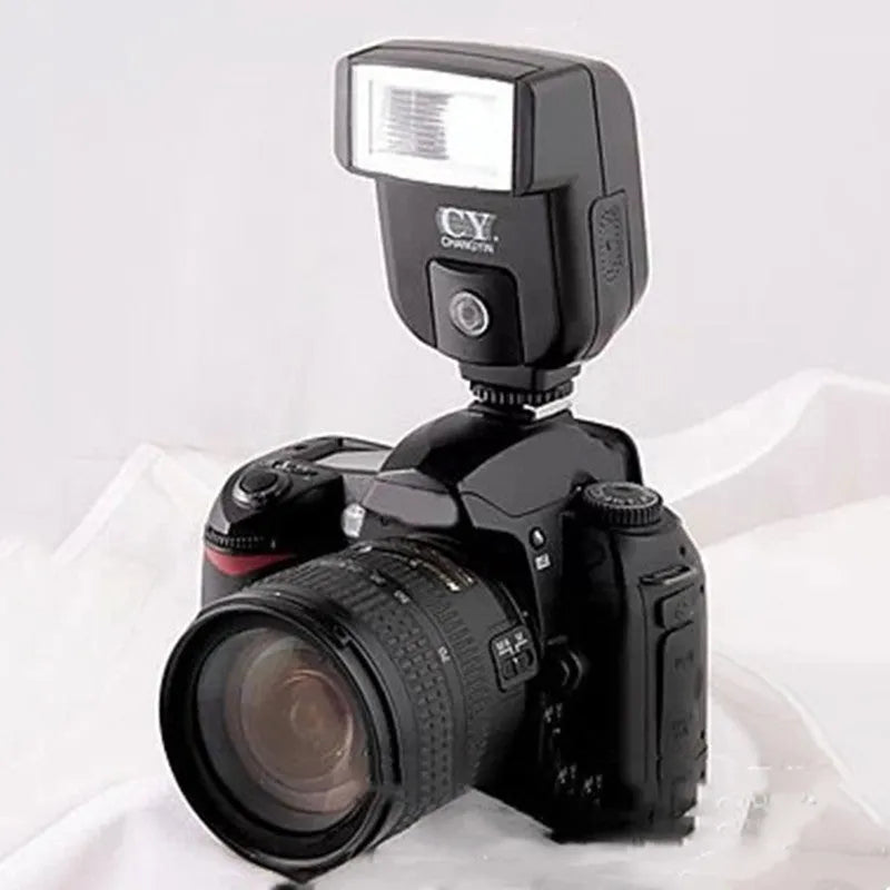 Compact silver SLR camera flash with a 90-degree adjustable bounce head on a hot shoe mount.