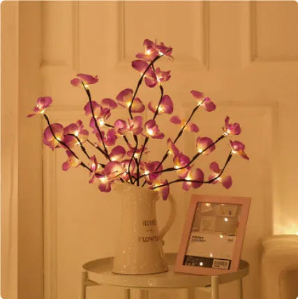Pink LED phalaenopsis orchid branch decorative light, 65cm long, with warm white illumination on battery power.