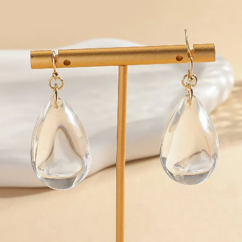 Transparent glass or crystal teardrop drop earrings with irregular shape and cold-tone finish for women