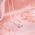 Close-up of a silver cherry pendant necklace on an adjustable snake bone chain, showing the fruit detail and spring ring clasp.