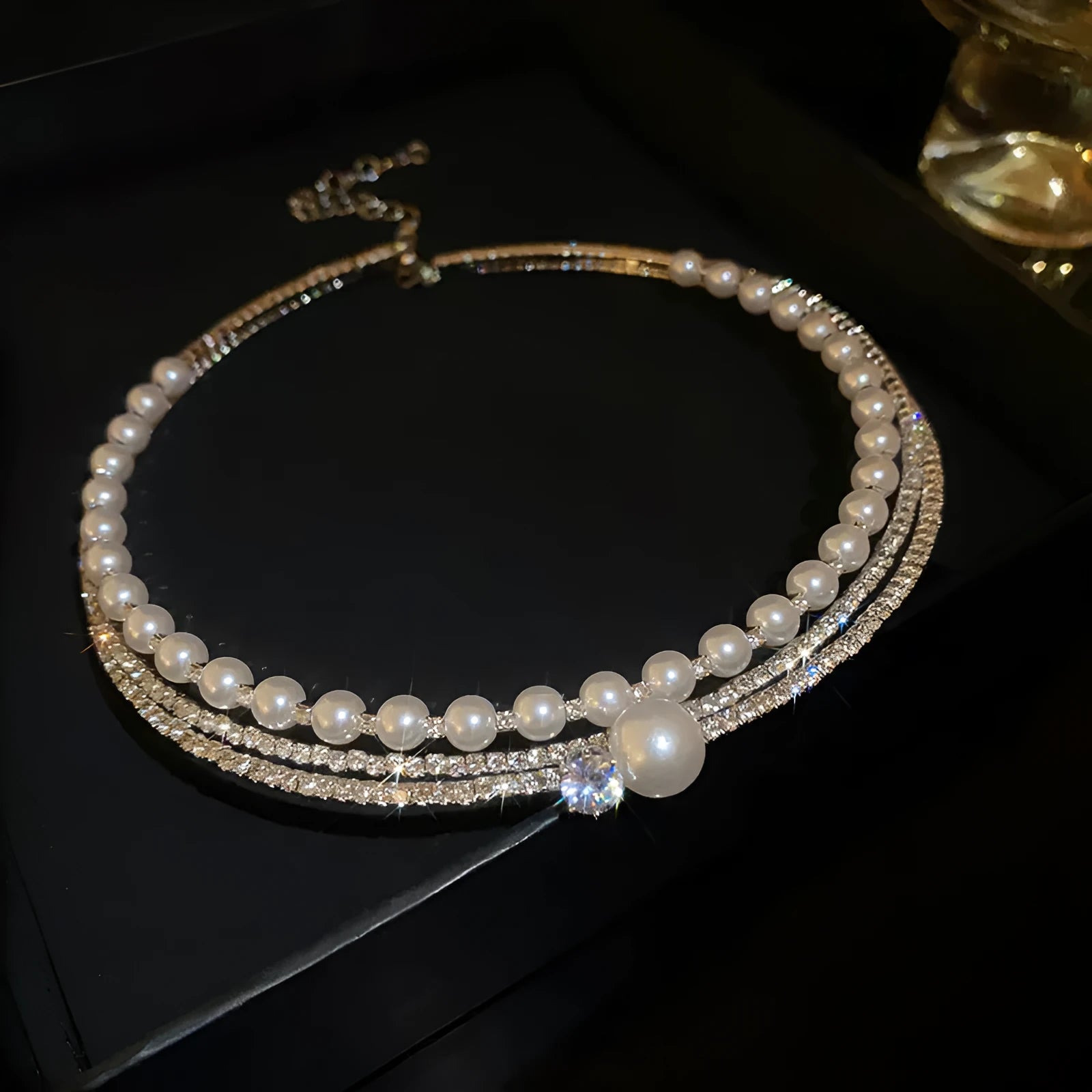 Curved geometric silver necklace resting on a woman's collarbone, showing its contour and electroplated finish.
