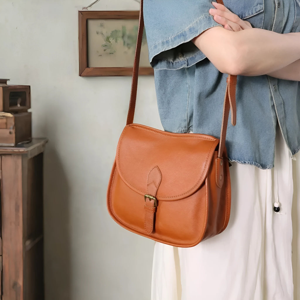 Brown genuine leather messenger bag with flap closure and crossbody strap showing internal organiser compartments