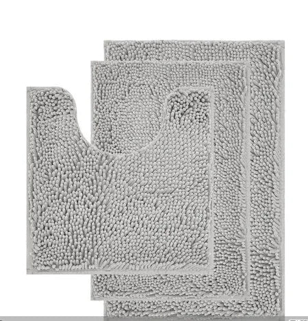 Dark green chenille U-shaped toilet mat with two matching rectangular bathroom mats on a tiled floor.