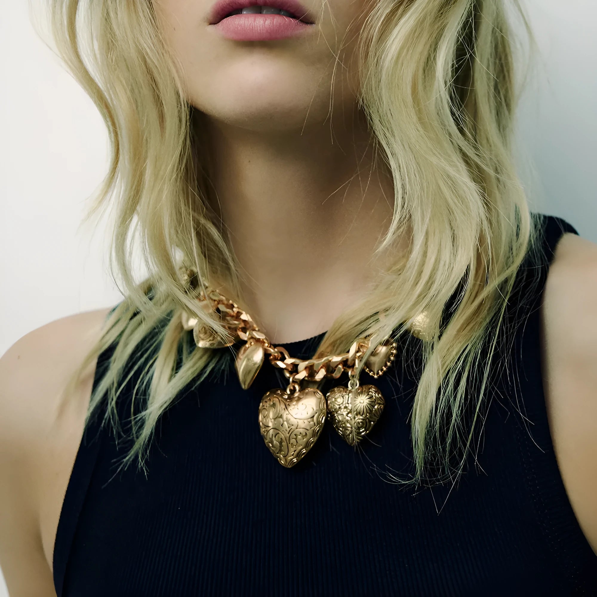 Gold carved heart-shaped pendant necklace on an adjustable metal chain.