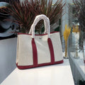 Genuine leather and canvas women's crossbody tote bag in bucket style with soft handle.