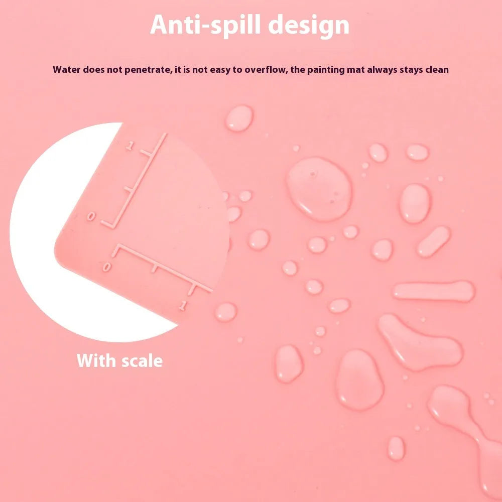 Light blue silicone painting mat with two round bowls, placed on a wooden table with paintbrushes.