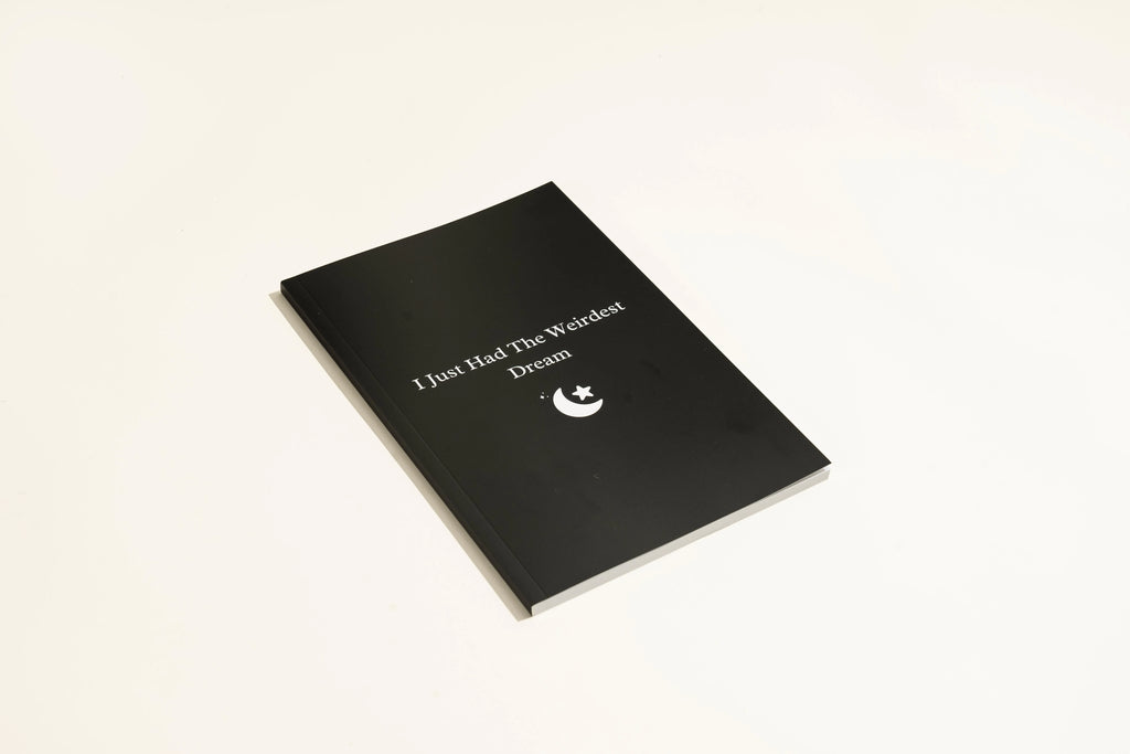 Black cover Dream Journal notebook with business simplicity styling, open on a page.