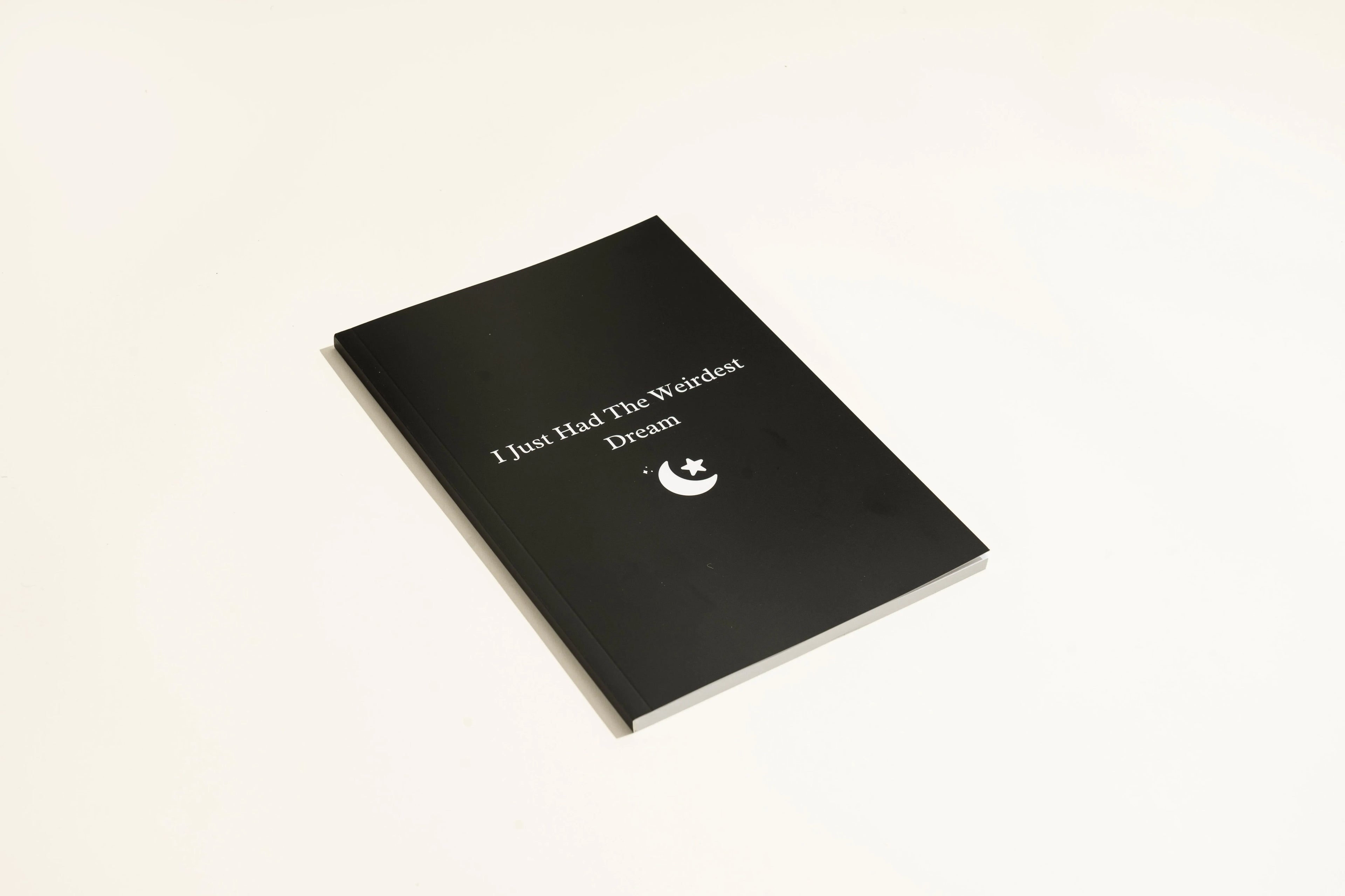 Black cover Dream Journal notebook with business simplicity styling, open on a page.