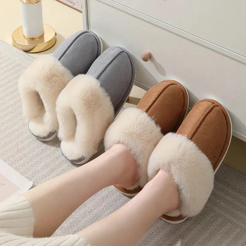 Brown plush indoor slippers for women with a non-slip PVC sole on a wooden floor.