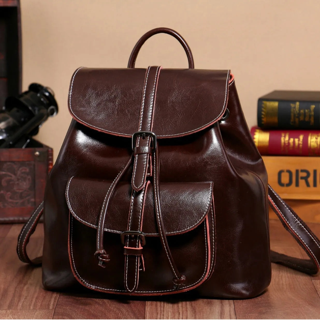 Korean style brown cowhide leather backpack with pull-belt fastening and front sandwich pocket.