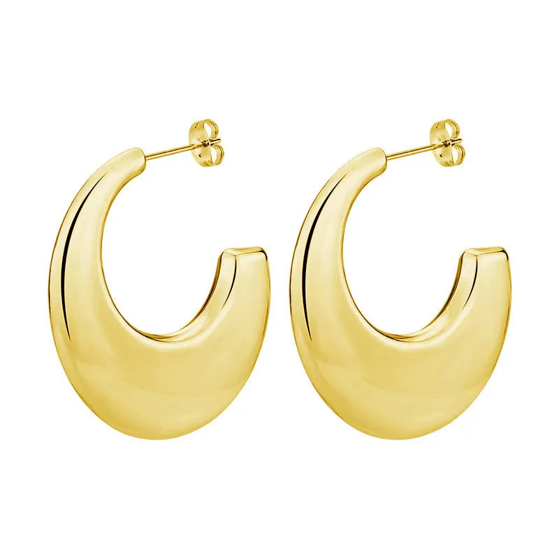 Two pairs of geometric thread stud earrings in gold and steel colour on a flat surface