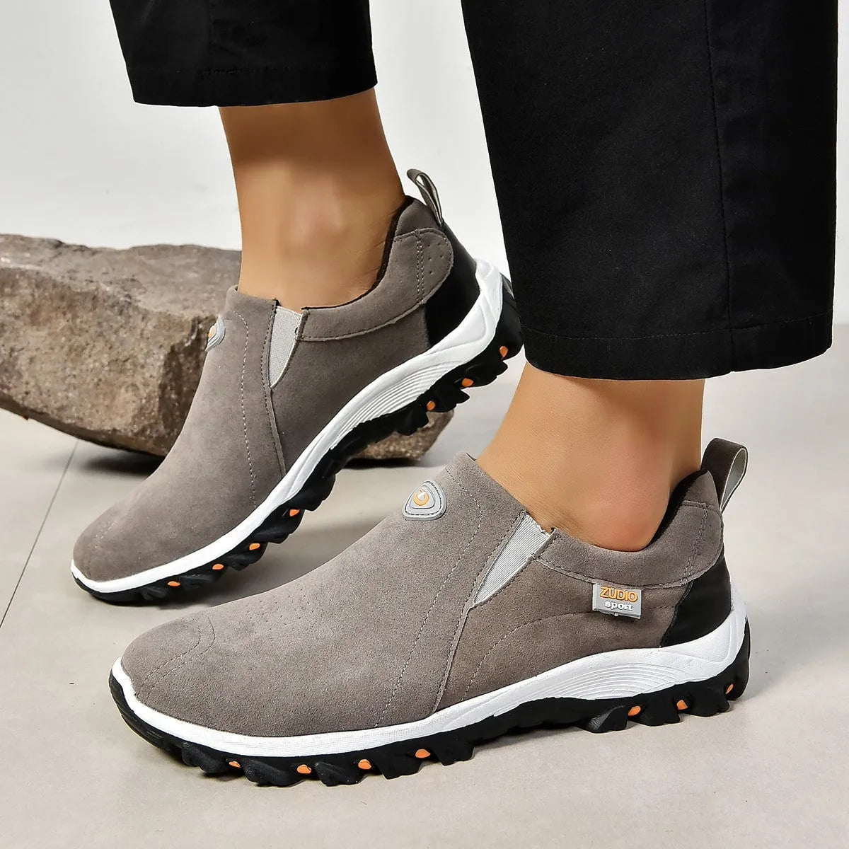 Men's grey slip-on shoe cover with round toe and rubber sole, shown from the side.