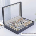 Grey leather watch storage box with a transparent dust cover, showing internal watch slots.