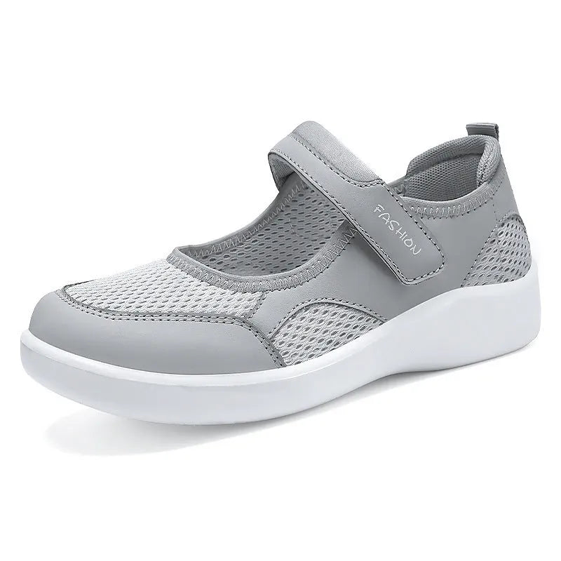 Women's low-top grey mesh casual trainers with Velcro fastening and a flat polyurethane sole.