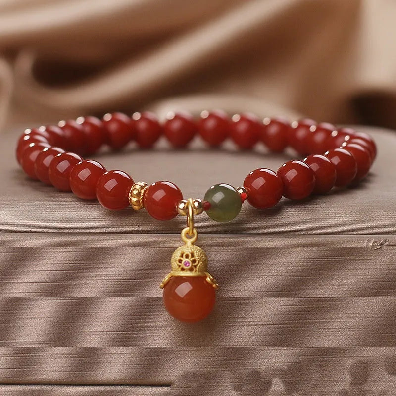 Red agate and Hetian jade bracelet with lucky beads pendant on display